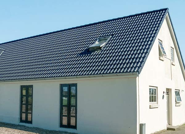 Nachher: Haus mit neuem Satteldach und Dachfenster nach Dachsanierung