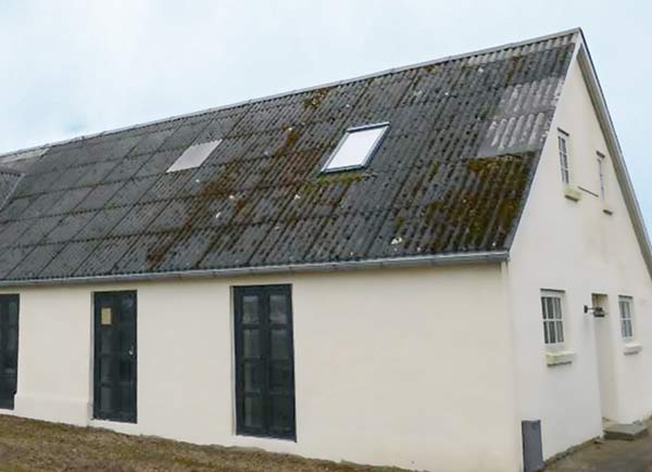 Vorher: Haus mit beschädigtem Satteldach und Dachfenster vor Dachsanierung